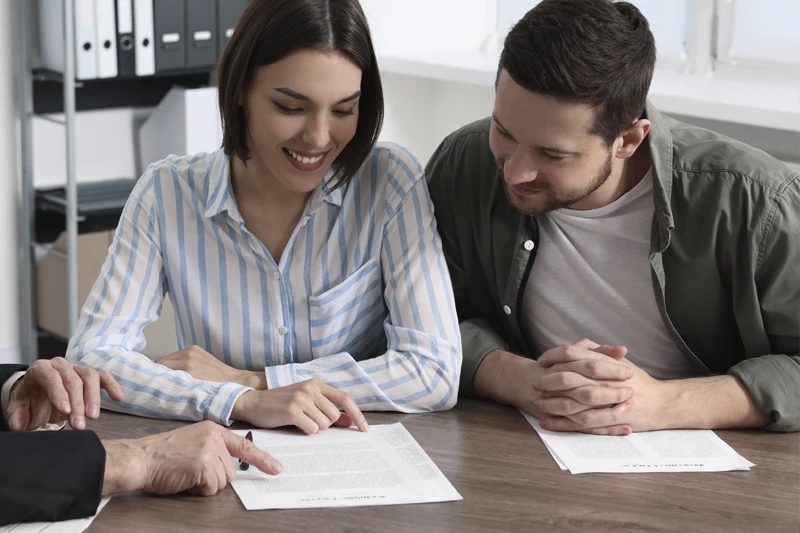 młoda para czyta umowę rezerwacyjną mieszkania